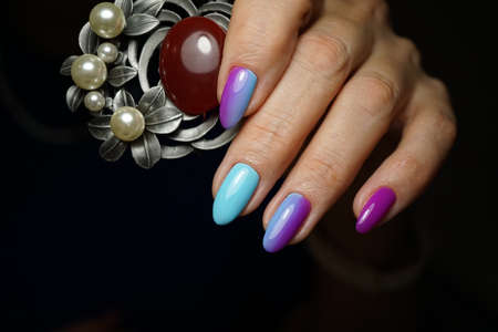 Beautiful bright natural nails with perfect clean manicure. Nail drill machine and cuticle nipper are used simultaneously to make such a clean manicure.の写真素材