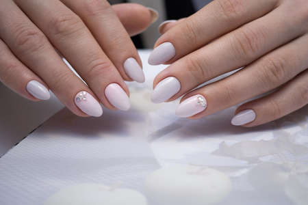 The beauty of the natural nails. Perfect clean manicure for the bright people. Nail drill machine and cuticle nipper are used simultaneously to make such a clean manicure.の写真素材