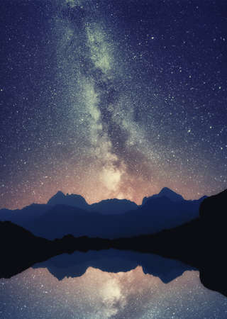 Milky Way over the Udziro lake, Racha, Georgia. Galaxy starscape with mountain silhouette.