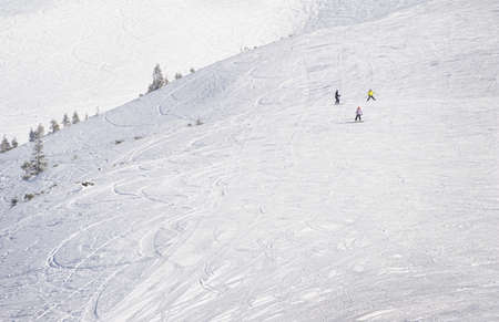 Young snowboarders on ski slope in high mountains. Winter background with snow traces and copyspaceの写真素材