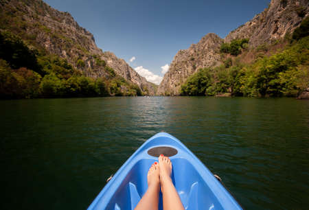 Kayaking through river in Matka canyon, Macedonia. Woman legs in the blue kayakの写真素材