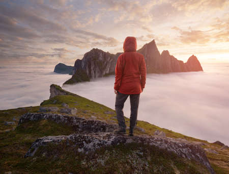 A tourist enjoying a view at the Mountain Hesten, Senja, Norway. Trekking in Norway, active life conceptの写真素材