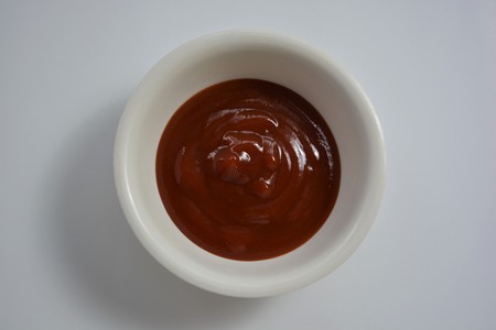 Tomato ketchup in a bowl on white background.の写真素材