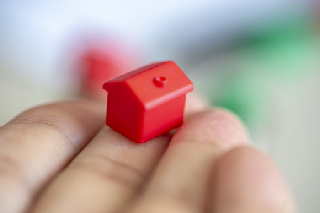 Hand with red miniature house on blurred background. Man hand.の写真素材