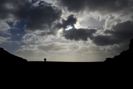 A couple walking on a beach in sunsetの写真素材