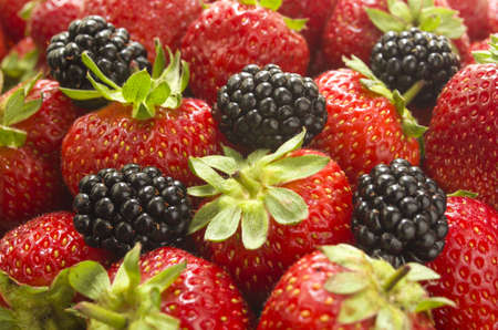 Ripe, juicy strawberries and blackberries. Bright background (selective focus)の写真素材