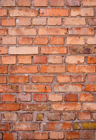 Brick wall texture, close up. Background with brickwork. The reddish surface of the building with grunge effect. Abstract wallpaper, portrait orientation.の写真素材