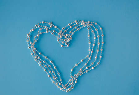 Heart shape of silver beads on the blue background. Festive banner template. Happy Valentines day. Love and romantic theme.の写真素材