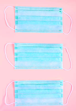 Medical mask on the pink background, top view. Surgical masks flat lay. Coronavirus protection. Stop Covid-19. Hygiene and healthcare theme. Global quarantine and social distancing. Creative banner.の写真素材