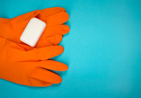 Rubber gloves with soap bar, top view. Cleaning service. Wash your hands. Hygiene and health care. Latex gloves on blue background with copy space.の写真素材