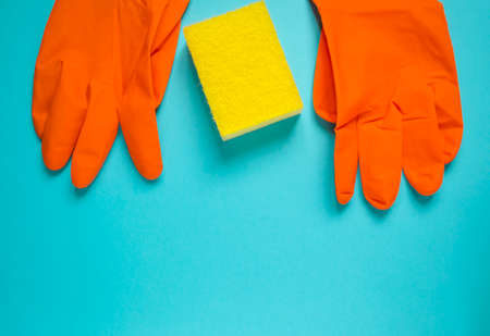 Rubber gloves with sponge top view. Cleaning service. Latex gloves with washcloth on blue background. Advertising for cleaning company. Banner template with copy space.の写真素材