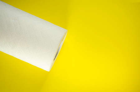 Toilet paper top view. Paper towel roll on yellow background. Hygiene stuff for everyday. Banner template with body care products and copy space.の写真素材
