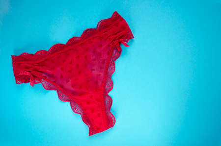 Red lingerie on blue background. Woman panty with copy space. Sexy underwear top view. Banner template for seasonal sales and discounts.の写真素材