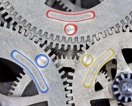 Macro photo of tooth wheel mechanism with colorful symbols; concept of teamworkの写真素材