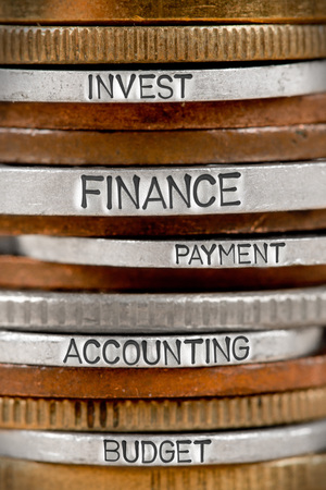 Photo of various stacks and rows of coins with FINANCE concept related words imprinted on metal surfaceの写真素材