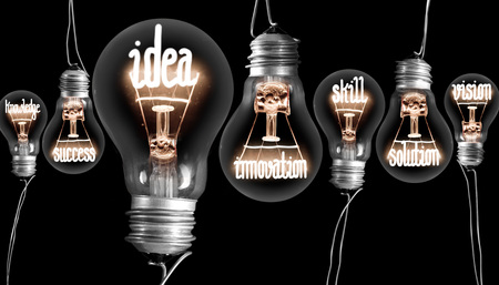 Light bulbs with shining fibers in a shape of IDEA concept related words isolated on black...