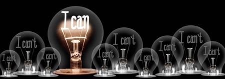 Large group of shining and dimmed light bulbs with fibers in a shape of I Can't and I Can words isolated on black background; concept of Motivation, Positivity and Changeの写真素材