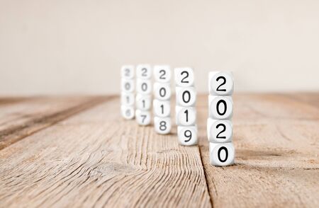 White cube blocks with 2020, 2019, 2018, 2017... imprinted; focused on 2020; concept of new year and...