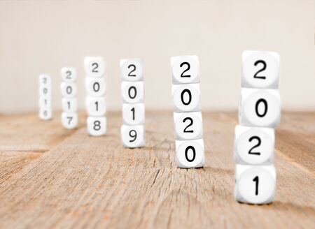 White cube blocks with 2020, 2021, 2019, 2018... imprinted; focused on 2020; concept of new year and...
