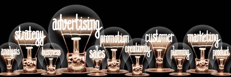 Large group of light bulbs with shining fibers in a shape of Advertising, Strategy, Customer and Marketing concept related words isolated on black backgroundの写真素材