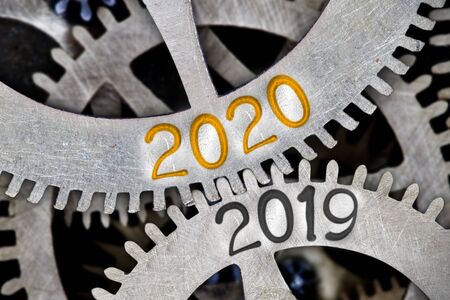 Tooth wheel mechanism with numbers 2020, 2019 imprinted on metal surface. New Year concept.の写真素材
