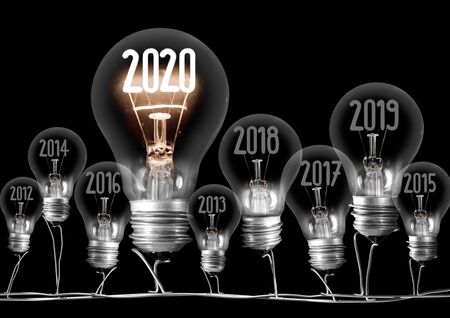 Group of shining and dimmed light bulbs with fibers in 2020, 2019, 2018  isolated on black background. New Year concept.の写真素材