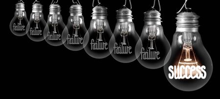 Group of shining and dimmed light bulbs with fibers in a shape of Failure and Success concept words isolated on black background.の写真素材