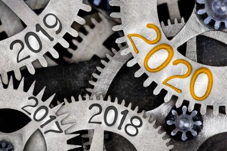 Photo of tooth wheel mechanism with numbers 2020, 2019, 2018... imprinted on metal surface. New Year, Future, Past and Time concept.の写真素材