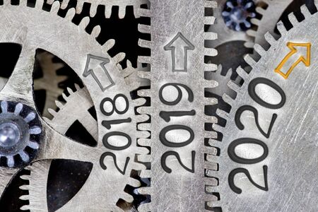 Photo of tooth wheel mechanism with numbers 2020, 2019 and 2018 imprinted on metal surface. New Year, Future, Past and Time concept.の写真素材