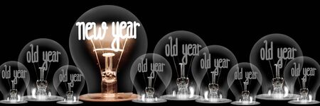 Horizontal group of shining a,d dimmed light bulbs in a shape of New Year and Old Year isolated on black background.の写真素材