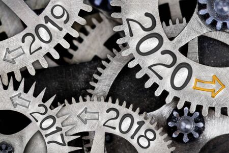 Photo of tooth wheel mechanism with numbers 2020, 2019, 2018... imprinted on metal surface. New Year, Future, Past and Time concept.の写真素材