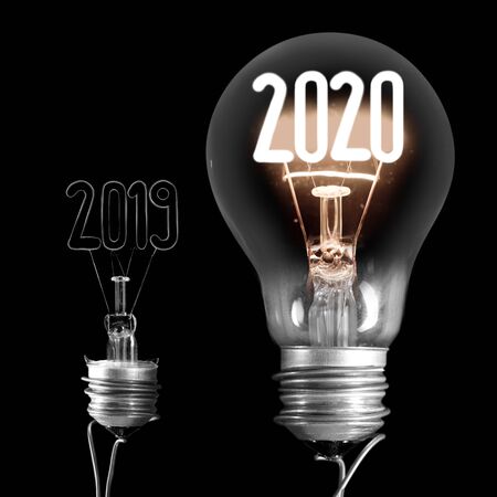Group of shining and broken light bulbs in a shape of New Year 2020 and 2019 isolated on black background.の写真素材