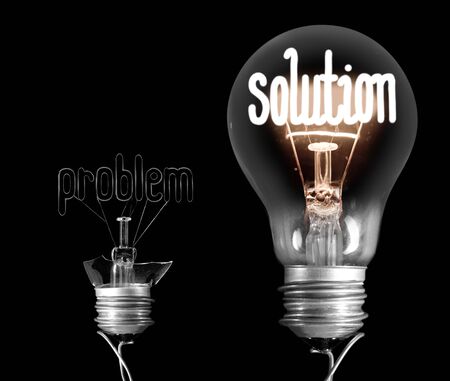 Foto de Photo of broken light bulb and shining one next to it with fibers in a shape of Problem and Solution concept isolated on black background - Imagen libre de derechos