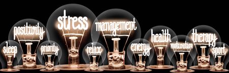 Group of light bulbs with shining fibers in a shape of Stress Management, Health, Therapy and Relax concept related words isolated on black background; horizontal compositionの写真素材