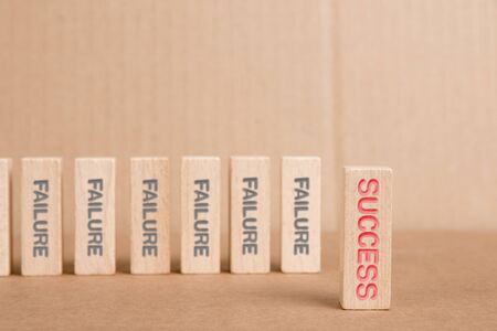 Wooden blocks with Failure and Success imprinted, one of them hold by a human hand. Concept of Motivation and Opportunity.の写真素材