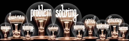 Photo of light bulbs with shining fibers in a shape of Problem Solving, Business, Goal, Efficiency and Idea concept related words isolated on black backgroundの写真素材