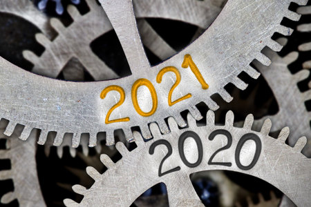 Photo of tooth wheel mechanism with numbers 2021 and 2020 imprinted on metal surface. New Year concept.の写真素材