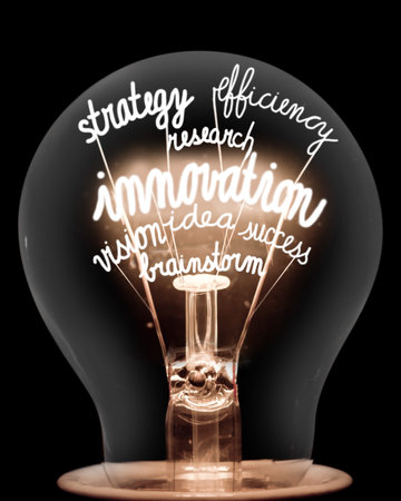 Photo of single light bulb with shining fibers in a shape of Innovation, Idea, Goal, Solution, Strategy and Vision concept related words isolated on black backgroundの写真素材