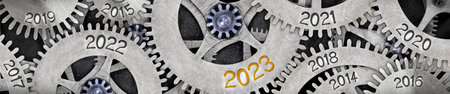 Photo of tooth wheel mechanism with numbers 2023, 2022, 2021... imprinted on metal surface. New Year...