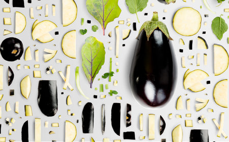 Abstract background made of Eggplant vegetable pieces, slices and leaves isolated on gray background.の写真素材