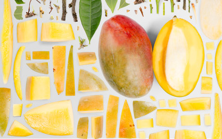 Abstract background made of Mango fruit pieces, slices and leaves isolated on gray background.の写真素材