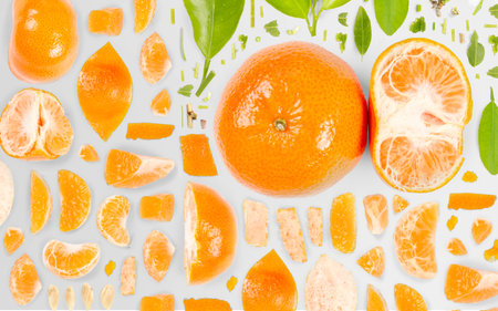 Abstract background made of Tangerine fruit pieces, slices and leaves isolated on gray background.の写真素材