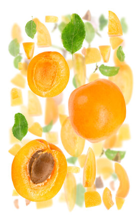 Abstract background made of Apricot fruit pieces, slices and leaves isolated on white.の写真素材