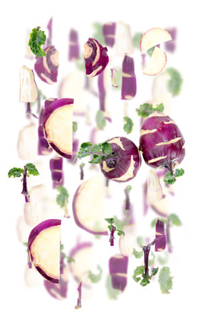 Abstract background made of Kohlrabi vegetable pieces, slices and leaves isolated on white.の写真素材