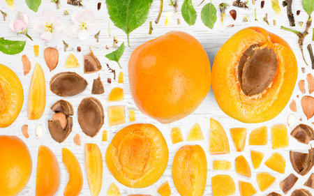 Abstract background made of Apricot fruit pieces, slices and leaves on wooden background.の写真素材