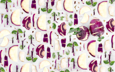 Abstract background made of Kohlrabi vegetable pieces, slices and leaves on wooden background.の写真素材