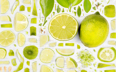 Abstract background made of Lime fruit pieces, slices and leaves on wooden background.の写真素材