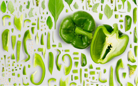 Abstract background made of Green Pepper vegetable pieces, slices and leaves isolated on gray background.の写真素材