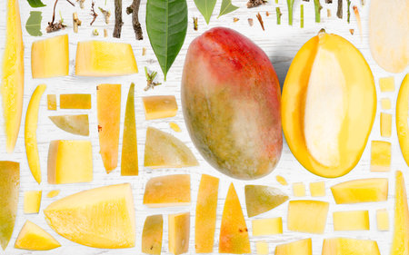 Abstract background made of Mango fruit pieces, slices and leaves on wooden background.の写真素材