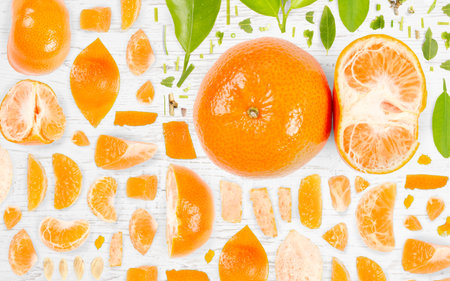 Abstract background made of Tangerine fruit pieces, slices and leaves on wooden background.の写真素材
